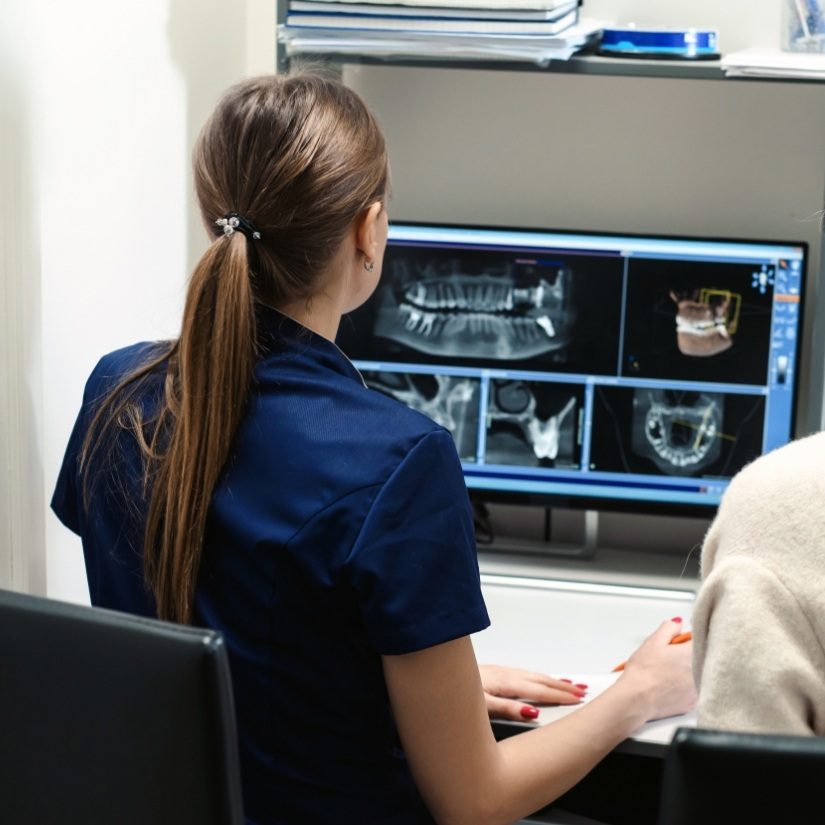 Dentist and dental team member looking at digital x rays