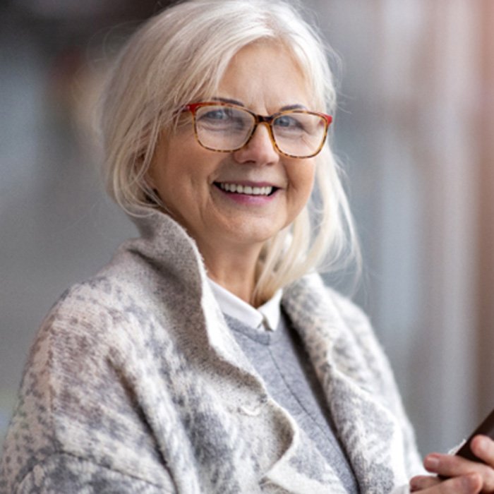 Senior woman with glasses looking at her phone