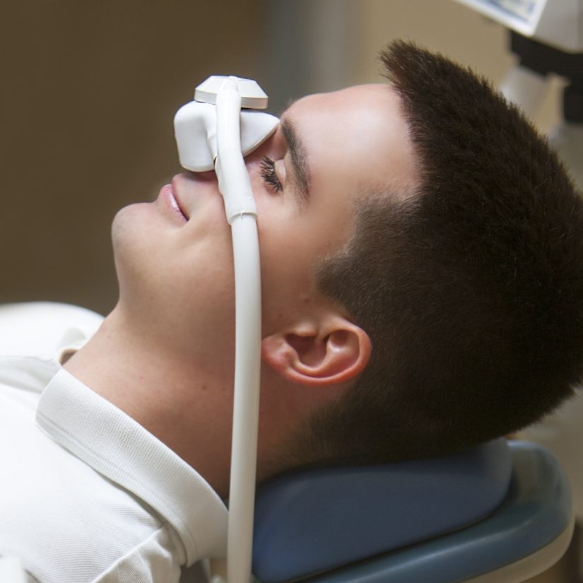 Dental patient receiving nitrous oxide sedation dentistry treatment