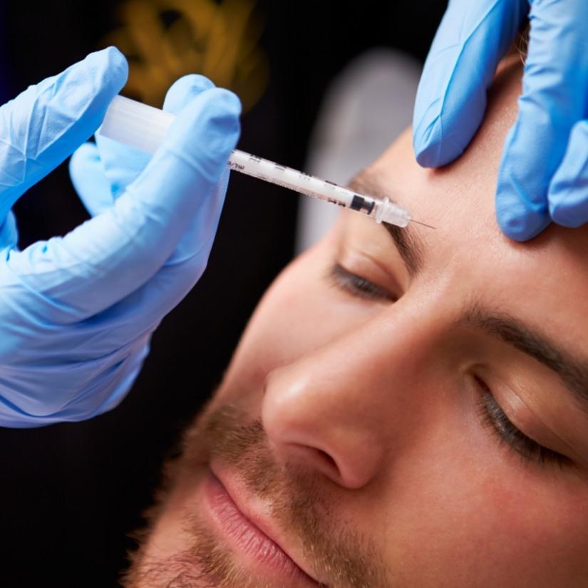 Man receiving Botox injection above eyebrow