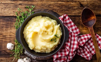 a bowl of mashed potatoes on a wooden table